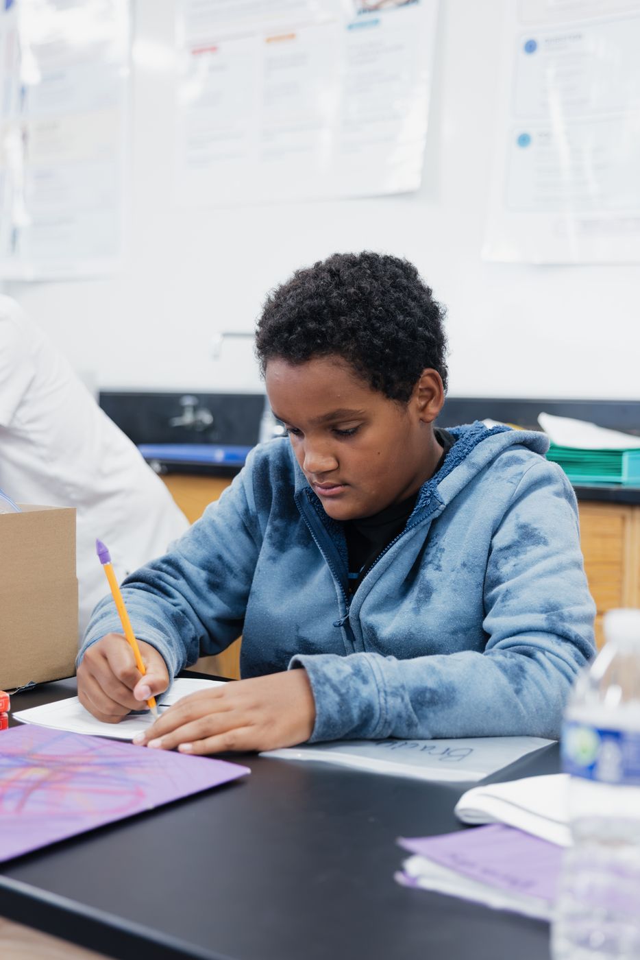 A student works through a problem in his notebook.
