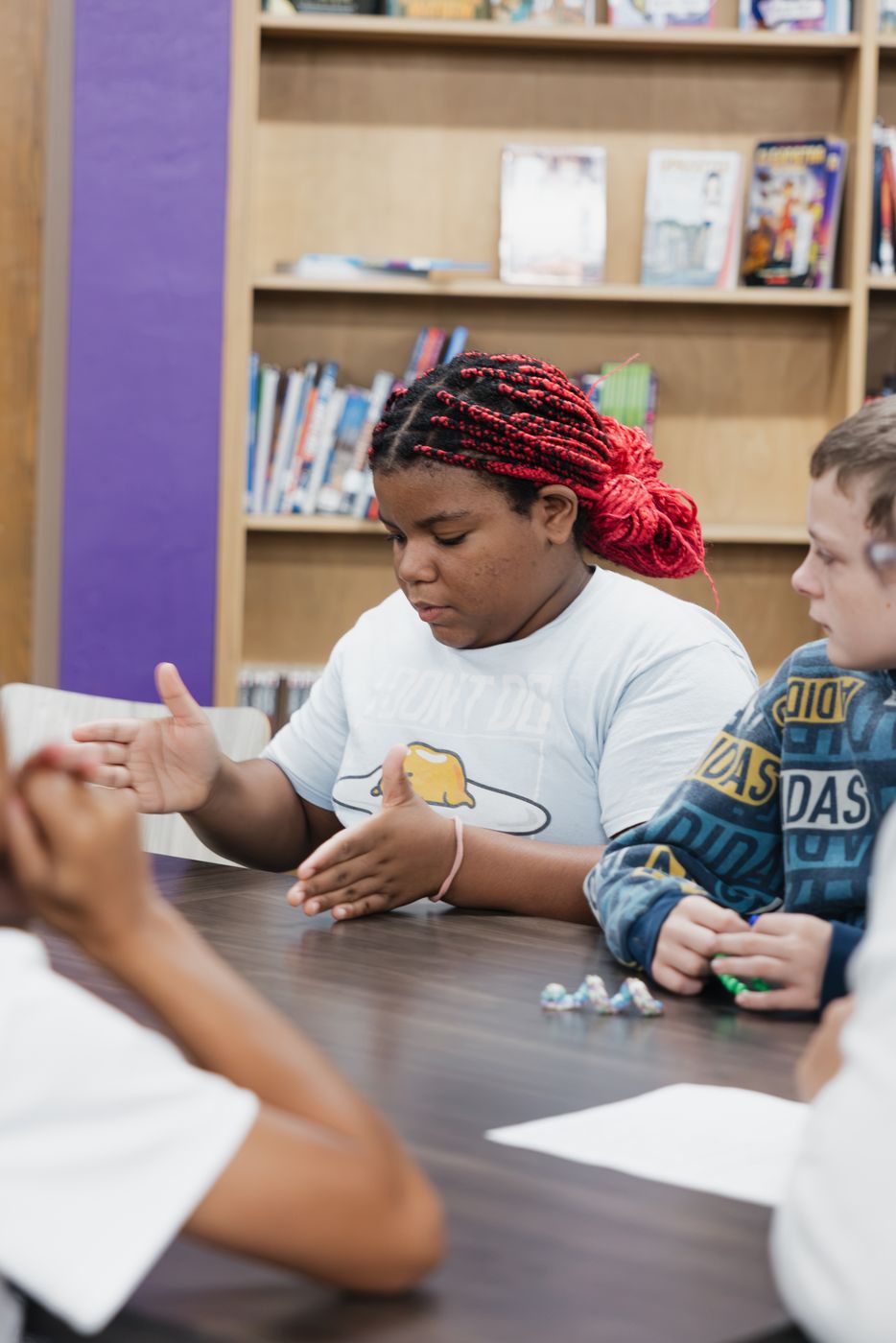 A student explains her thinking during a small-group discussion.