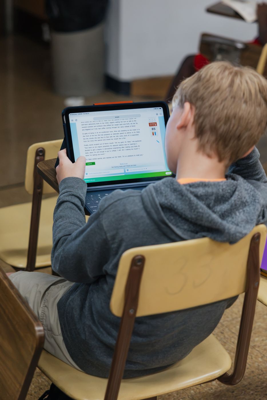 A student reads a passage on a tablet.