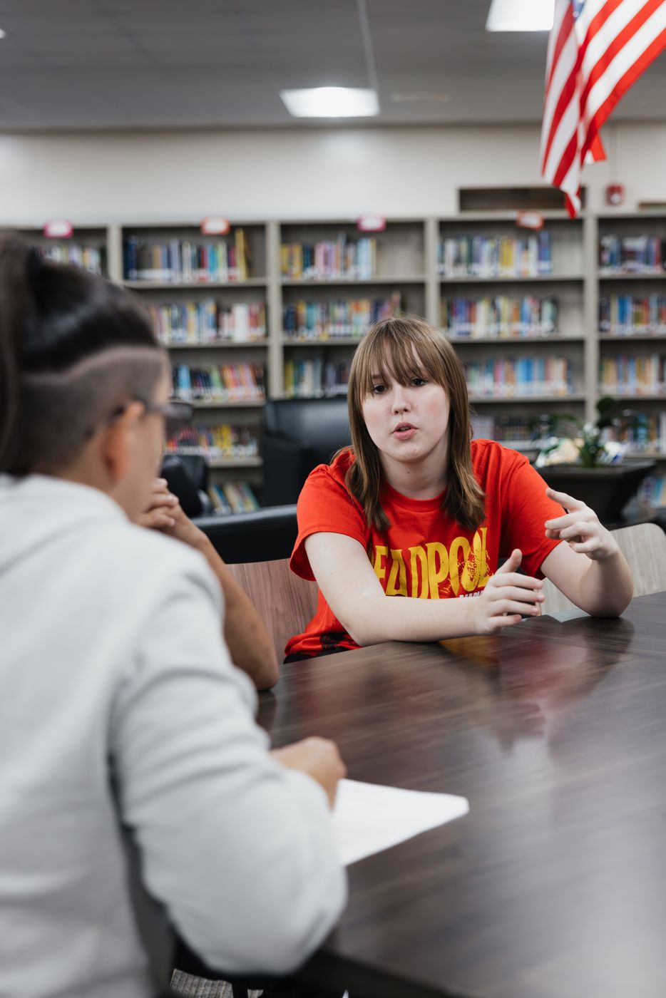 A student makes a point during a small-group conversation.