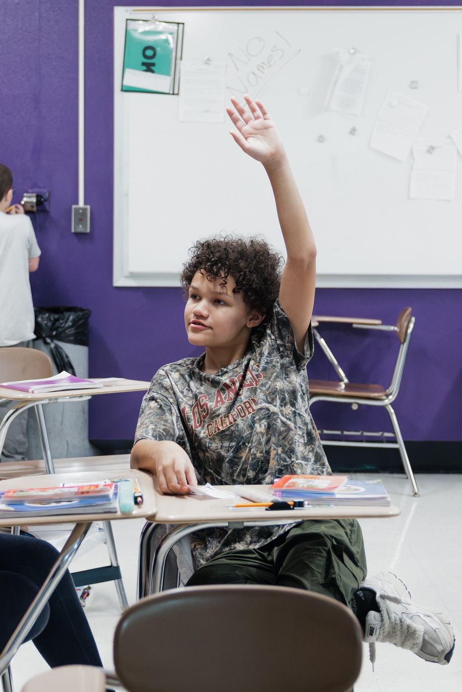 A student raises his hand to answer.